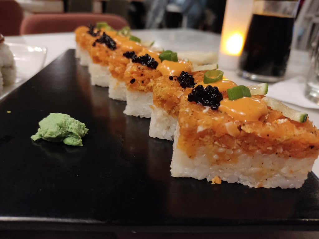 Sushi with white rice topped with orange vegan salmon