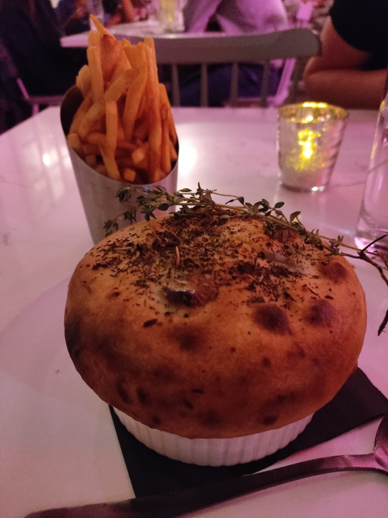 A pot pie crusted with herbs and some fries