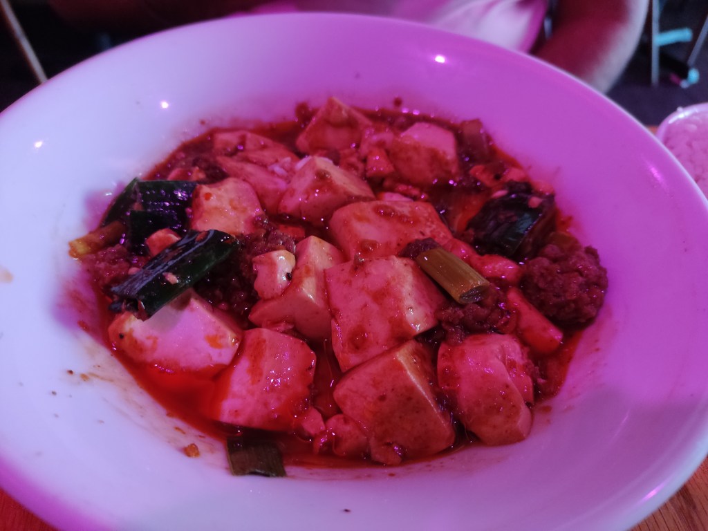 A big bowl of mapo tofu in a vibrant red sauce