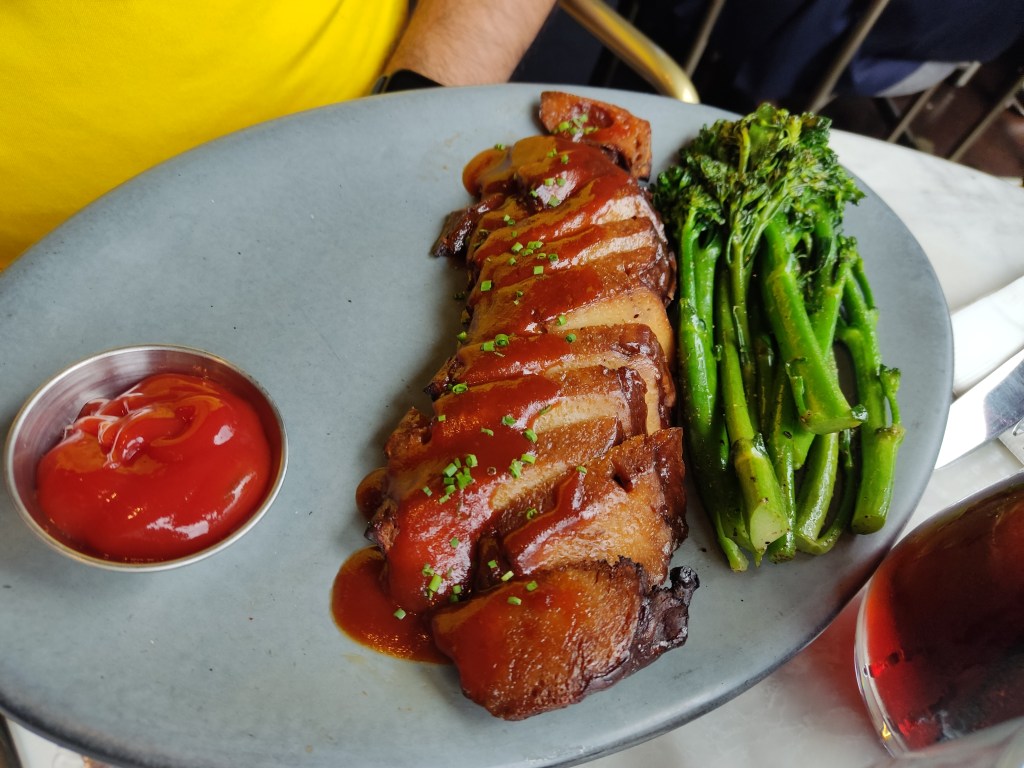 A big portion of nicely cooked mock meat, with a sticky glaze, served with broccoli and a portion of sauce