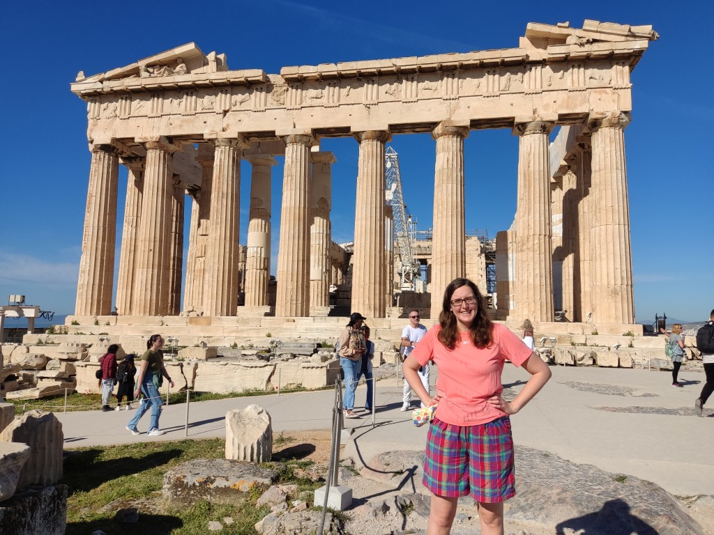 Jenny is standing in the sun in front of the Parthenon