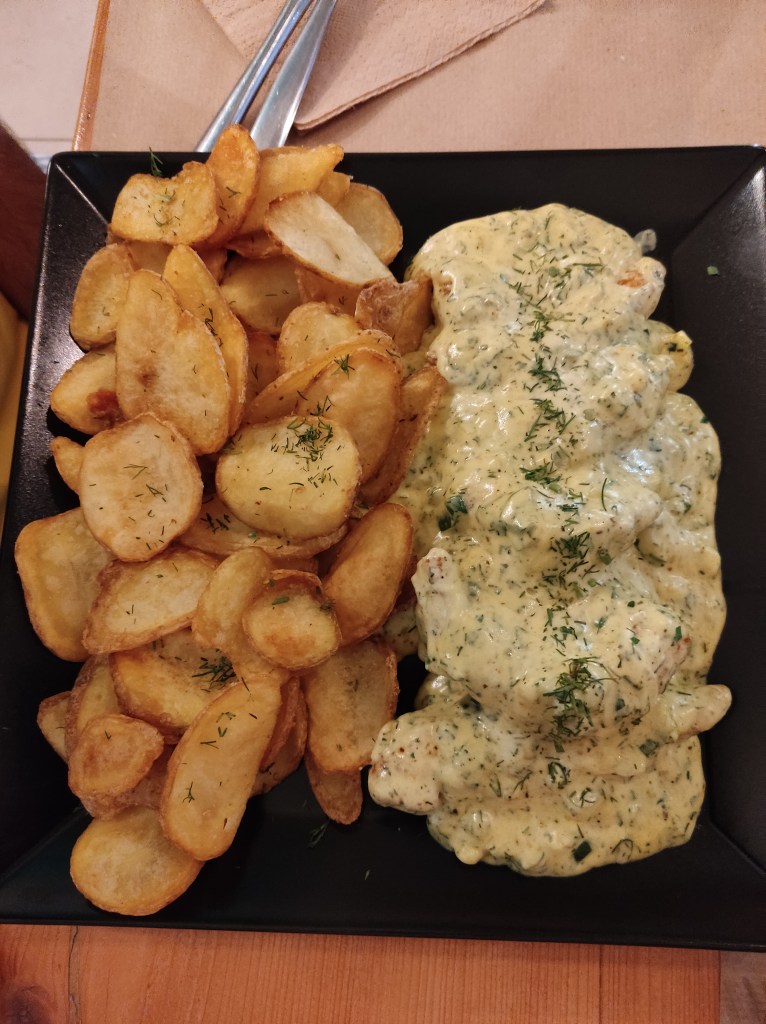 Fried potato slices and shrimps covered in a creamy sauce and dill