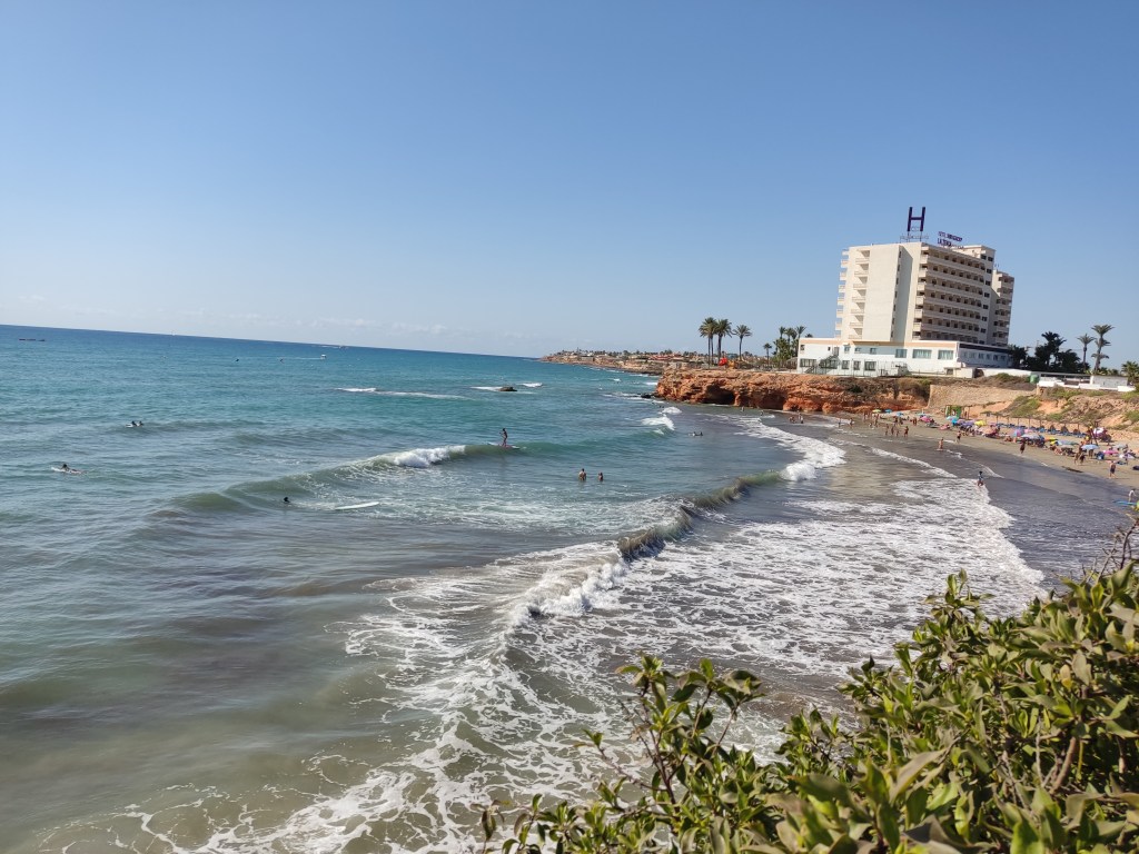 Surfers and swimmers in the sea, sunbathers on the beach