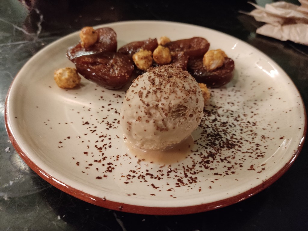 A scoop of ice cream and browned figs with hazelnuts