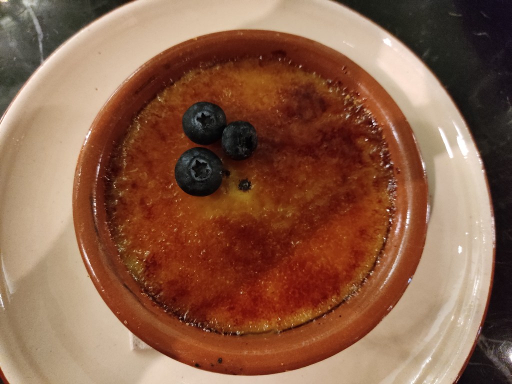 A perfect looking crème brulee with a few blueberries on top