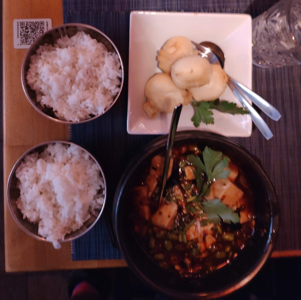 A bowl of mapo tofu, a plate with battered tofu, and two dishes of rice.