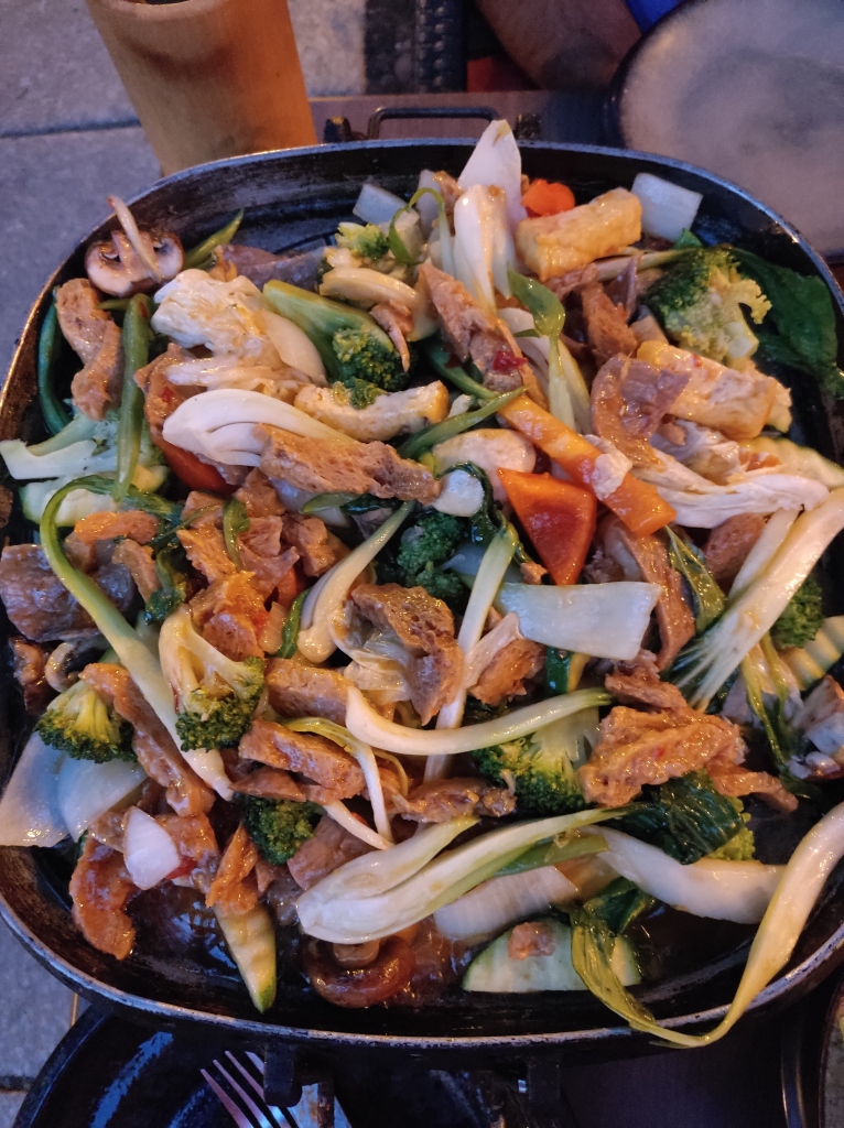 Vegetables and soy chunks cooking at a table top cooker