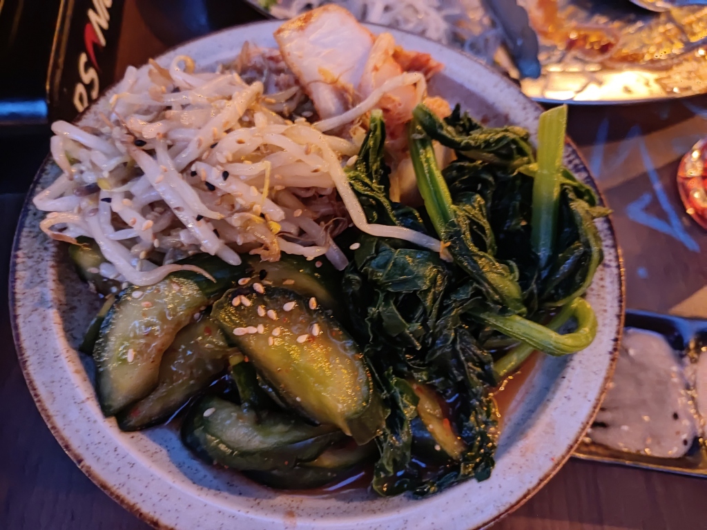 A dish almost overflowing with several different types of pickles
