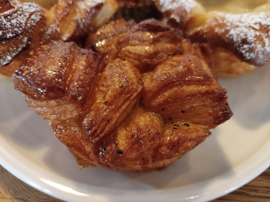 A cardamom croissant, which is not croissant shaped but more of a small round bun with lots of angular pieces on top