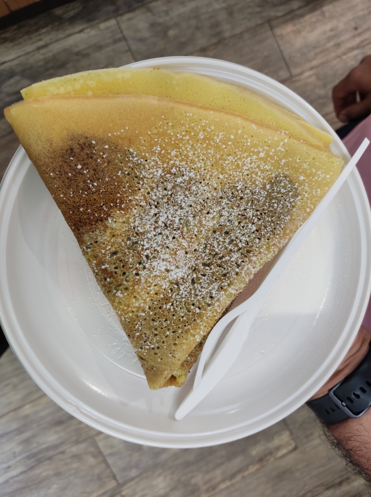 A crepe folded into a triangle with a chocolate filling just about visible