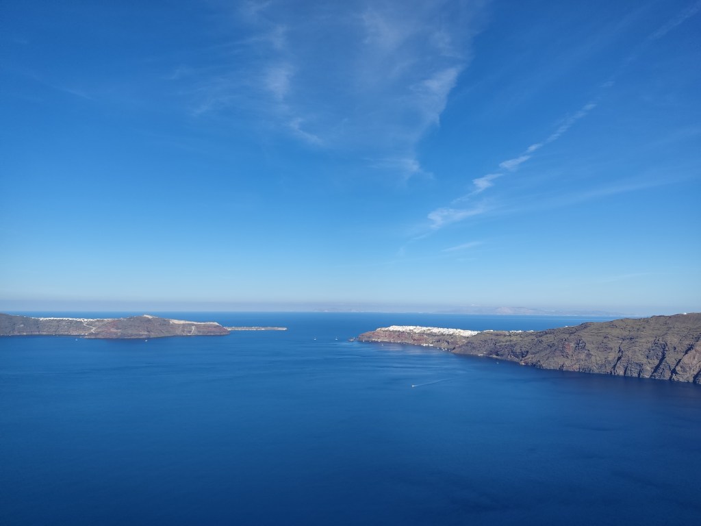 Blue sea and sky and the white buildings of Oia in the distance
