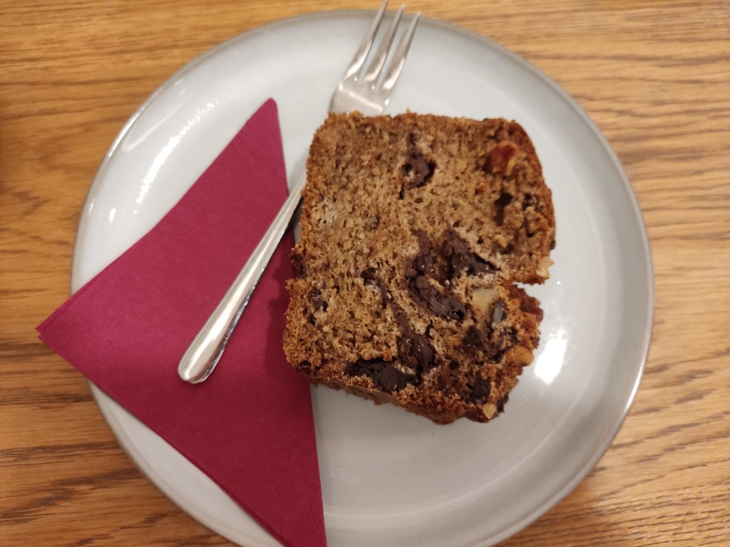 A big slice of banana bread filled with generous chocolate chunks and walnuts
