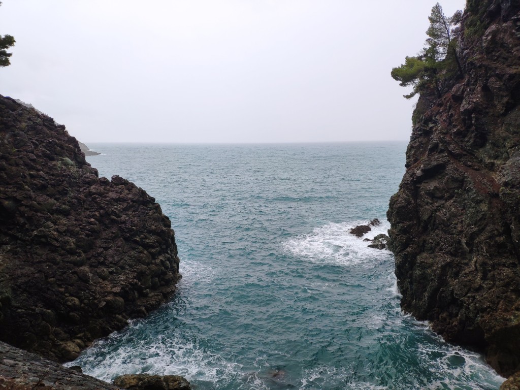 A view of the stormy blue sea and cliffs from the tunnel
