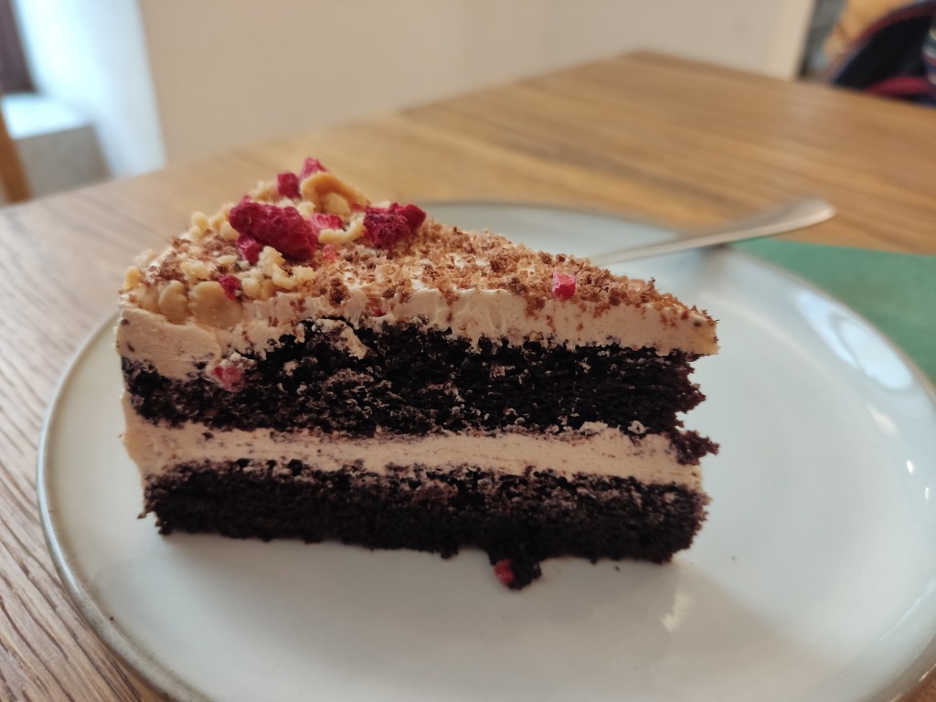 A slice of a chocolate layer cake with peanut butter cream in the middle and on top