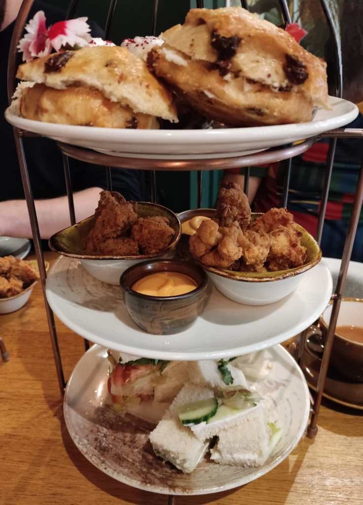 A three tiered afternoon tea stand filled with food