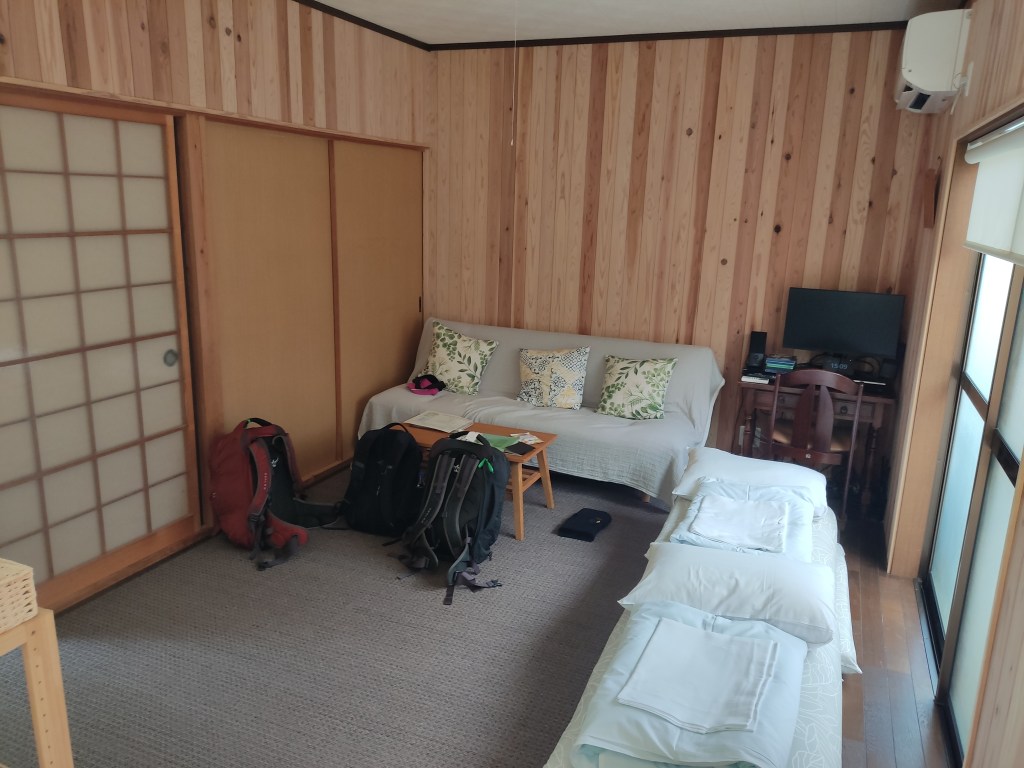 A room with traditional Japanese sliding doors and bedding