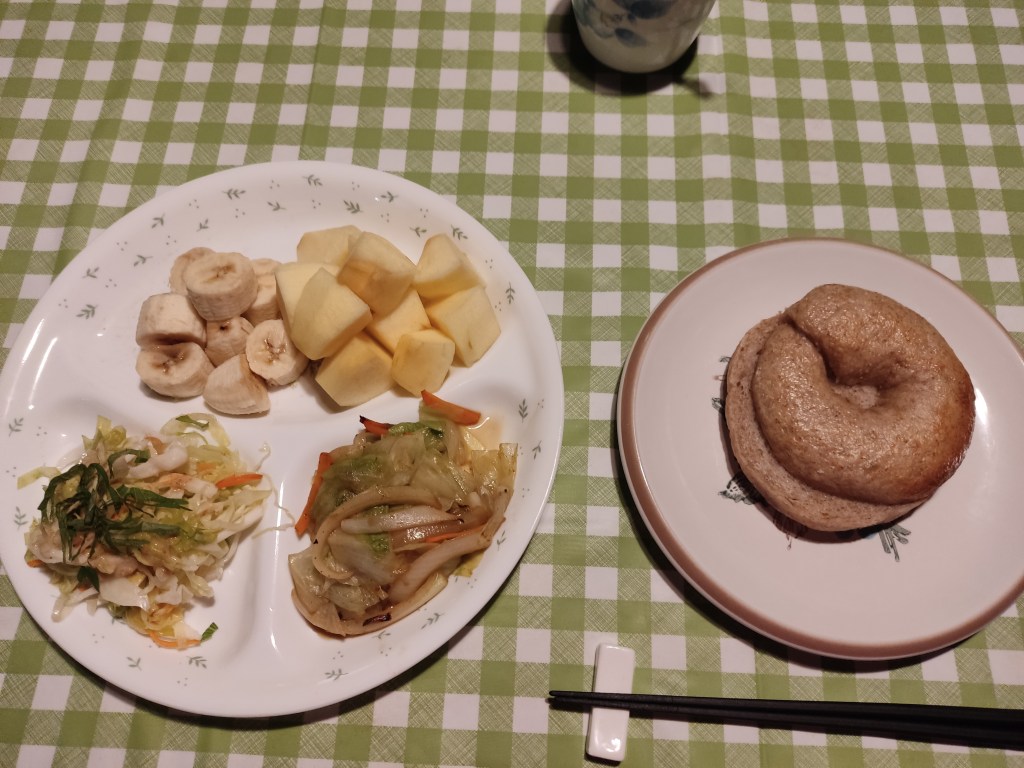 Chopped banana and apple, salad, cooked vegetables, and a bagel