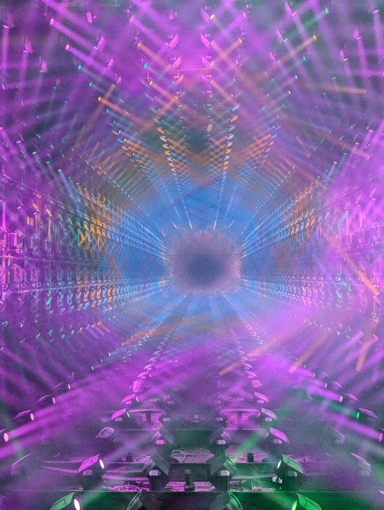 A light installation at teamlab Borderless, with lots of coloured beams of light projecting into patterns