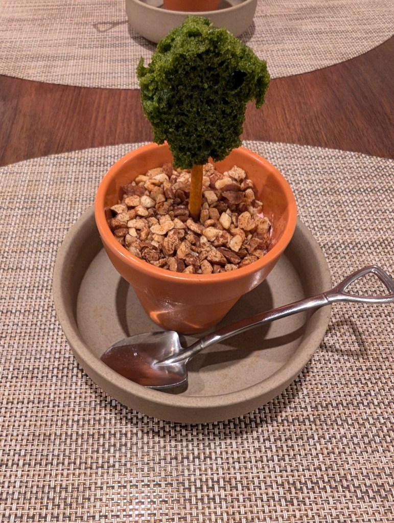 A plant pot and spoon shaped like a shovel. From the soil in the plant pot, an edible tree appears.