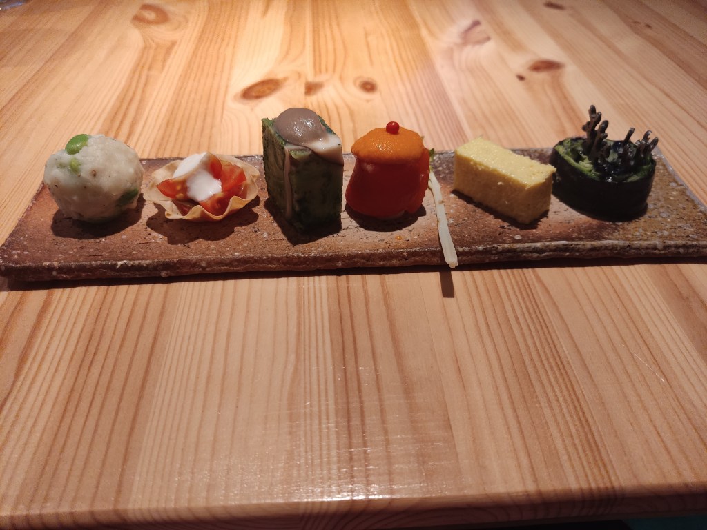 A plate containing six different vegetable bite sized dishes