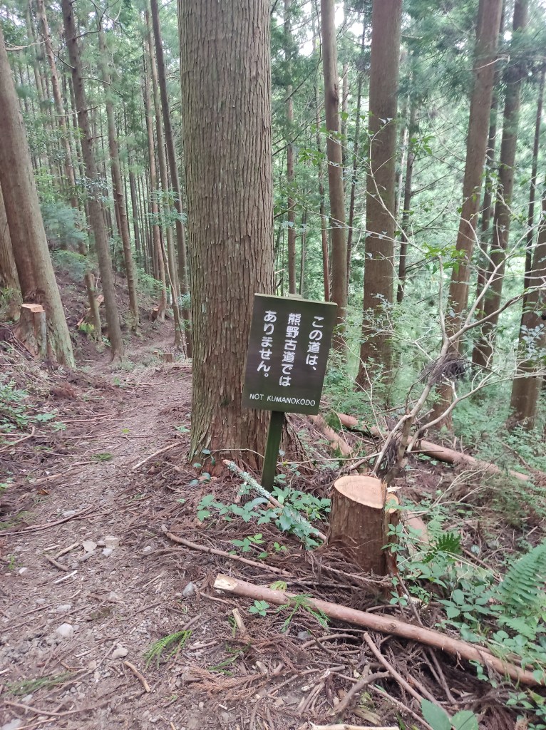A trail marked clearly with a "Not Kumano Kodo" signpost