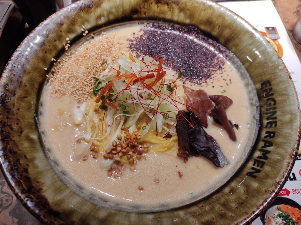 A creamy broth topped with a few different seeds and mushrooms