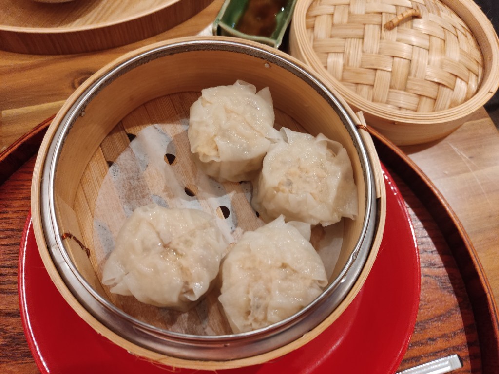A steamer containing four large dumplings