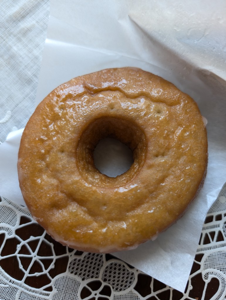 A ring donut glazed with a sugary syrup