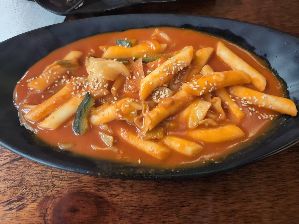 A bowl of tteokbokki in a red sauce