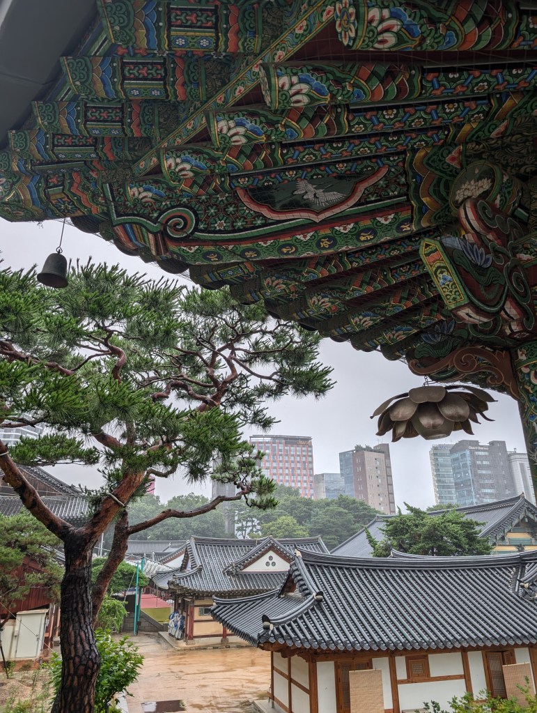 A corner of a building at the temple with city buildings in the distance