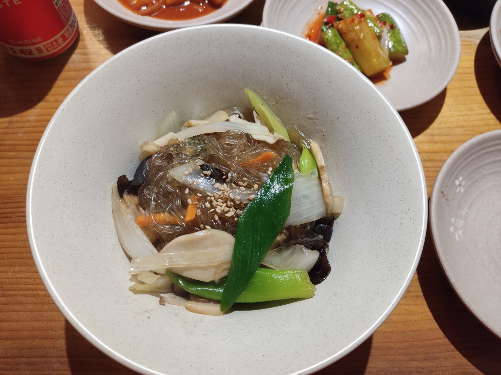 A big dish of japchae, glassy noodles and assorted vegetables
