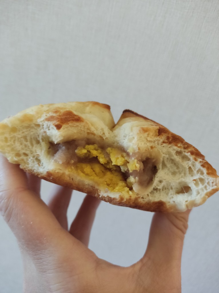 Inside a bun with yellow egg like pieces in the centre
