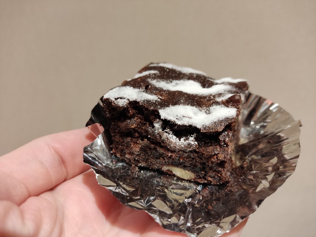 A square chocolate brownie on a foil wrapper