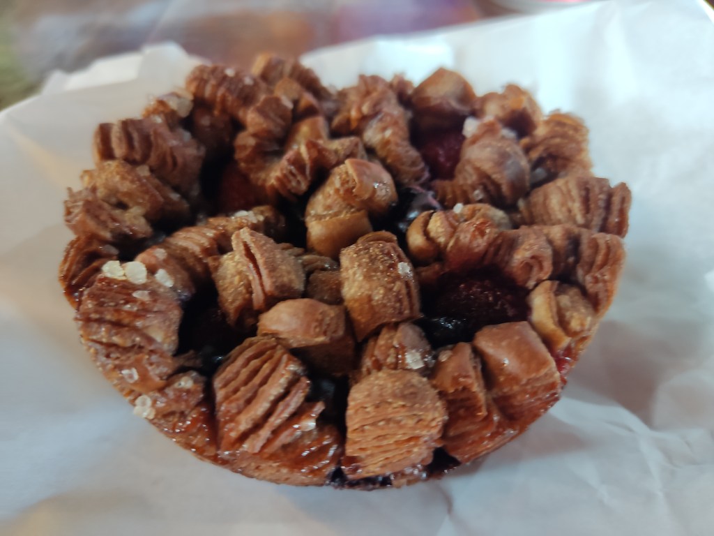 A brown croissant with sharp angles and juicy berries