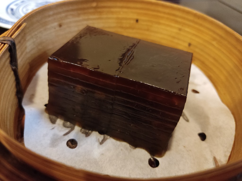 A steamer with two gelatinous looking pieces of striped dark brown cake