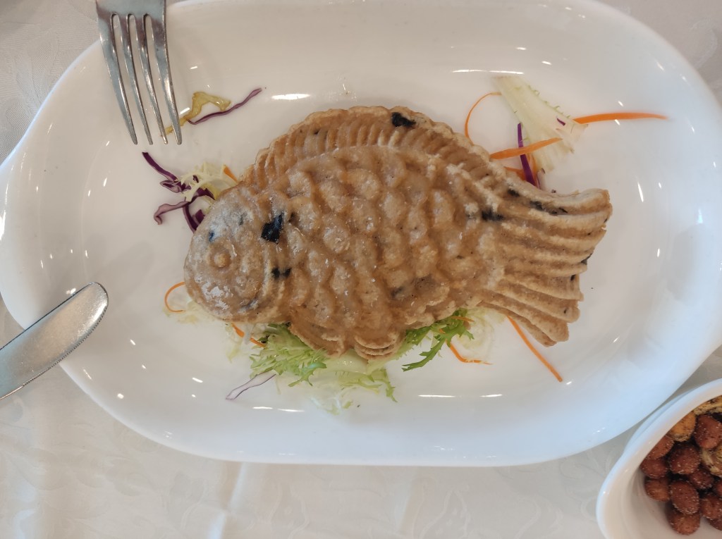 A dish that is shaped with a fish complete with face and scales