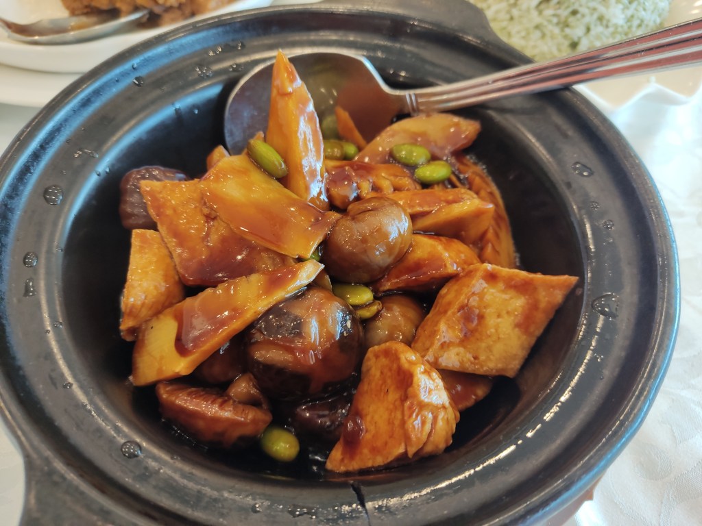 A hot pot filled with chestnuts, mushrooms and mock meat in a sticky sauce