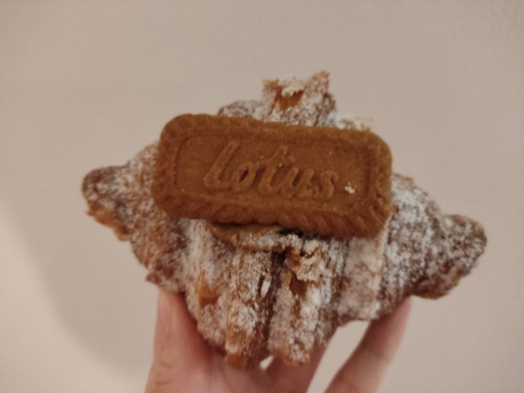 A croissant with a lotus biscuit on top