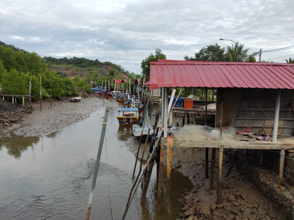 A small river lined with buildings on stilts