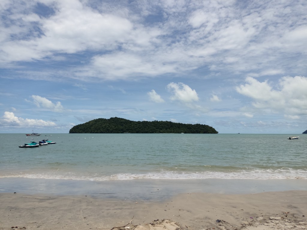 An island and boats off a sandy beach