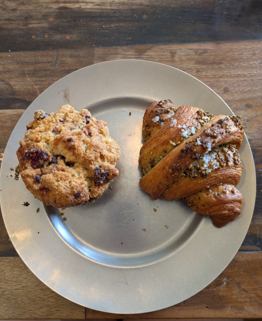 A large plate containing a muffin and a croissant