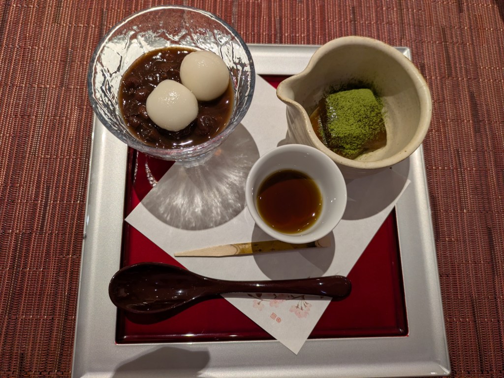 Two white rice cakes in a glass of sweet red bean soup, and warabi rice cake dusted with green matcha powder