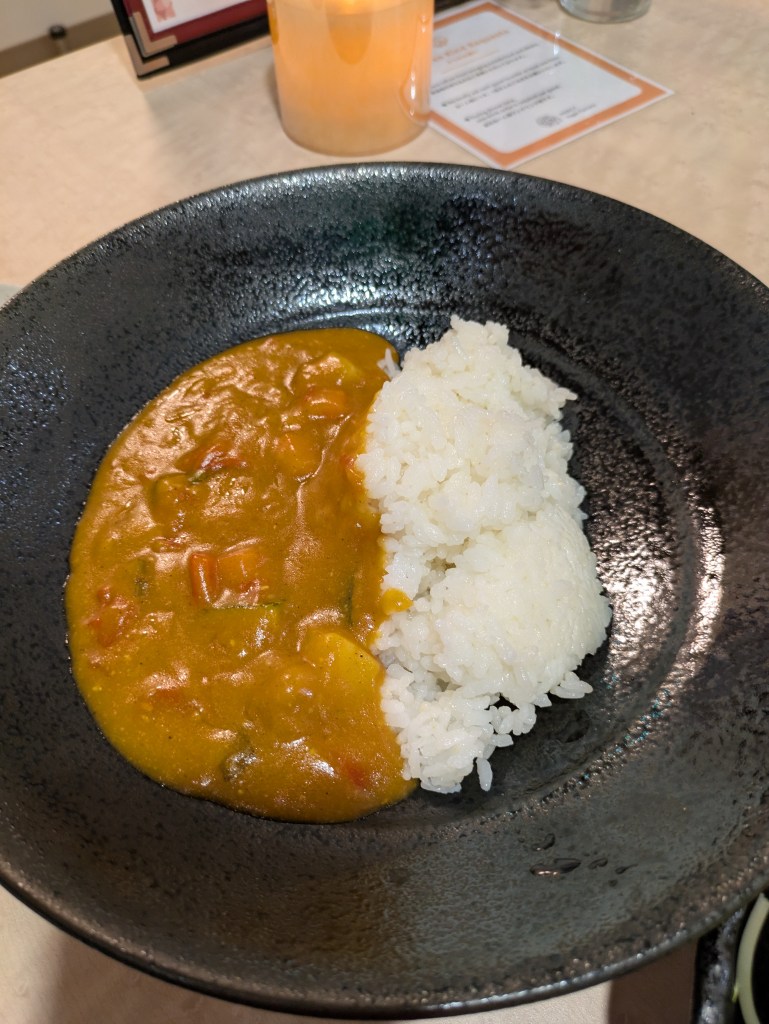 A large bowl of vegetable curry and rice