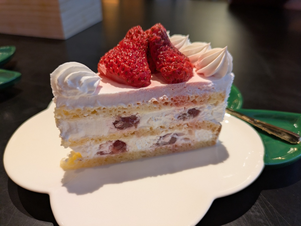A strawberry cake featuring three very thin layers of sponge and lots of cream