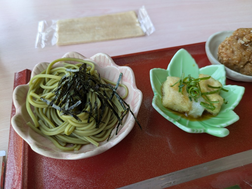 A small dish of cold matcha noodles and another with agedashi tofu
