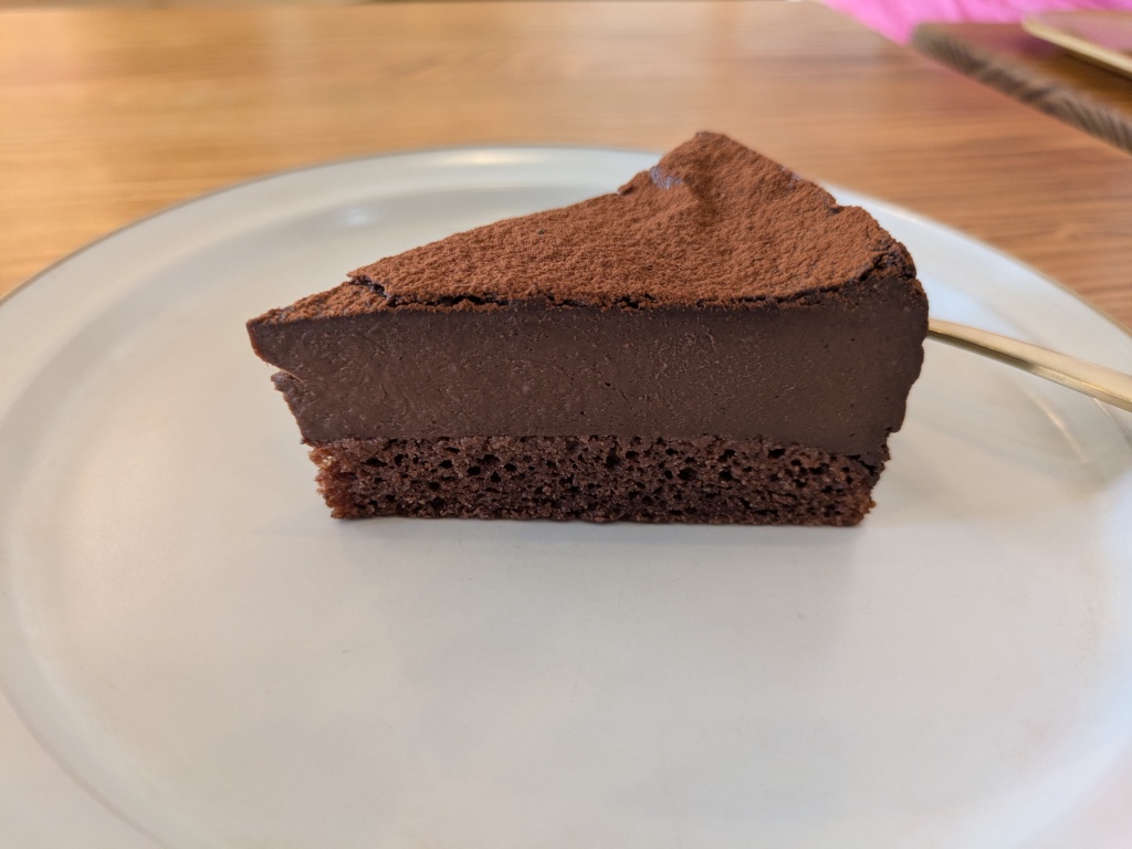 A chocolate cake with a fairly thin layer of sponge and a thick layer of chocolate cream.