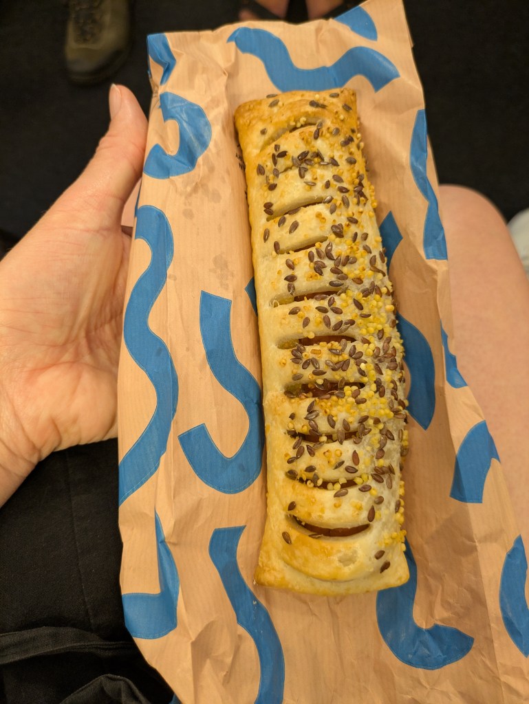 A sausage roll topped with seeds