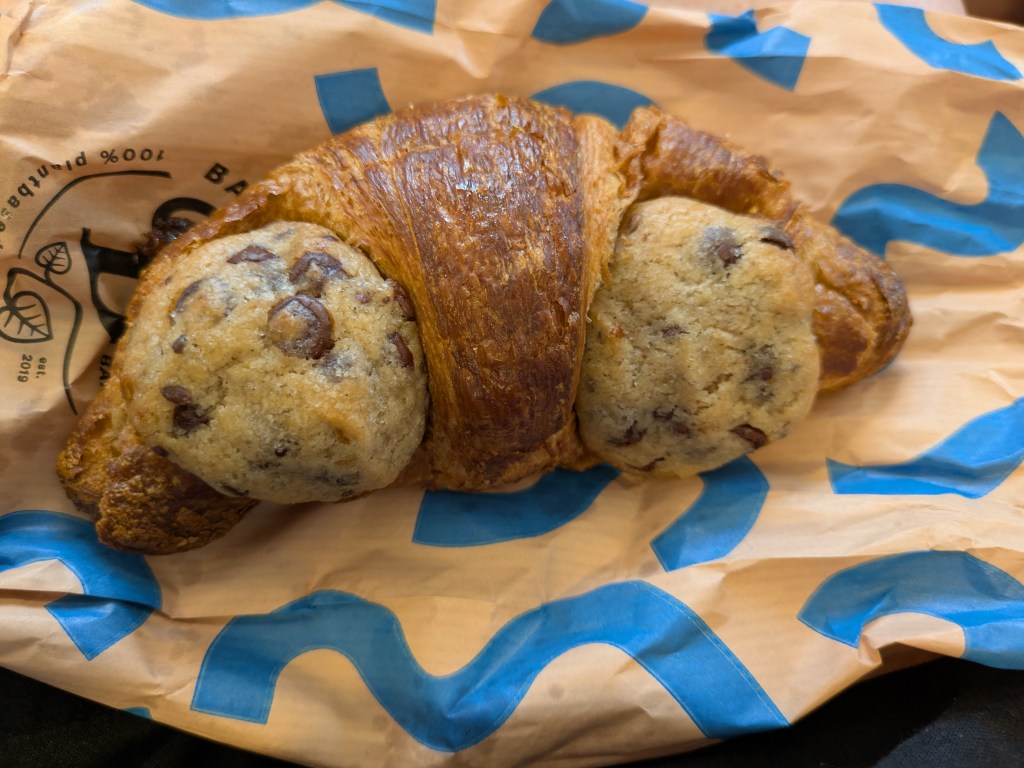 A croissant with a small cookie baked in at each end