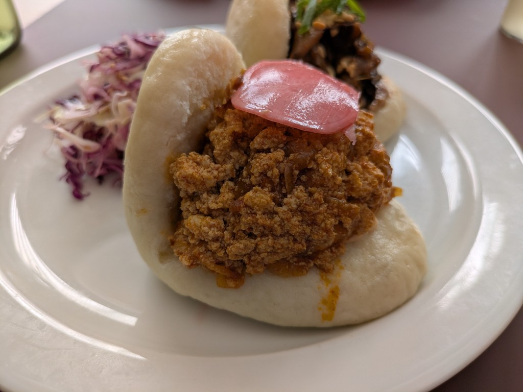 A fluffy bao bun filled with saucy scrambled tofu