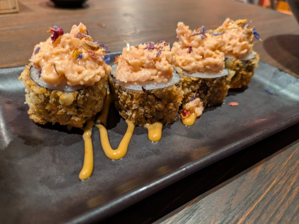 Four crispy sushi rolls topped with tuna